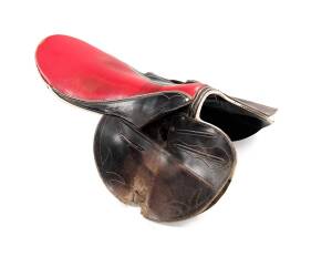 GARRY MURPHY'S RACING SADDLE, well-worn red & black racing saddle, used by Garry Murphy, and loaned to Noel Harris to win the 1988 Cox Plate on Our Poetic Prince, and later used by Garry's son Sebastian. Together with jockey's pants &nbsp;from Garry & Sebastia