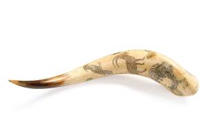 A scrimshaw powder horn decorated with birds, animals and portraits ♦