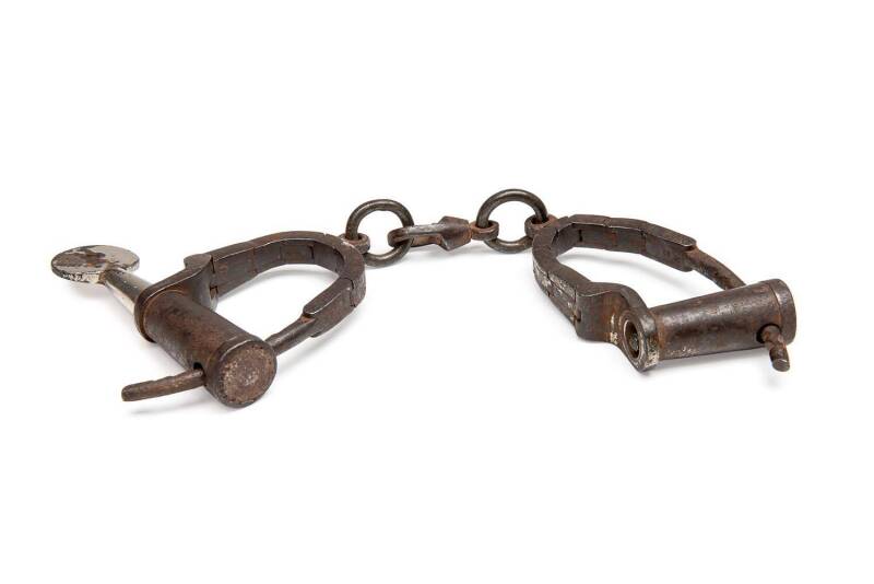 A pair of articulated manacles with key