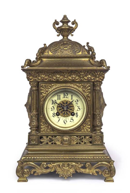 An ornated brass cased mantel clock with enamel dial