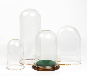 Four assorted glass domes, one with base, 19th century