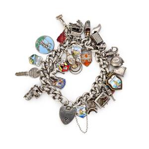 A silver charm bracelet, of curblink design, hung with twenty-five various charms. Length 18cm.