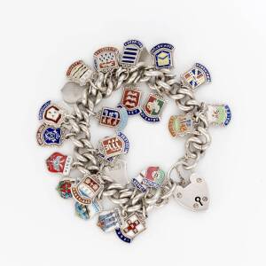 A silver charm bracelet, of curblink design, hung with approximately thirty travel charms. Length 18cm.