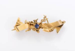 A goldfields bar brooch, late 19th century with crossed shovel and pick with small gold nuggets and a blue doublet