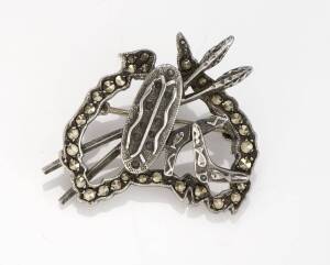 An Australian silver mounted marcasite brooch designed as a map of Australia with a shield, crossed spears and boomerangs