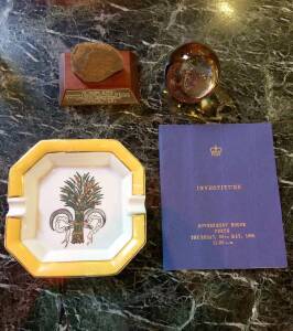 A collection of desk accesories, including a paperweight, a Limoges ashtray, photo frame, a bound investiture, Government House 1985 - Alan Bond to receive Order of Australia and a commemorative rock donated by YPO Perth Chapter 1984