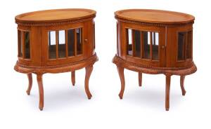 A pair of oval glazed side cabinets with removable oval tray tops
