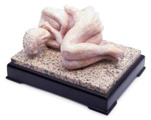 A stone sculpture of a female lying in a clasped hand inscribed on foot with initials "AB"