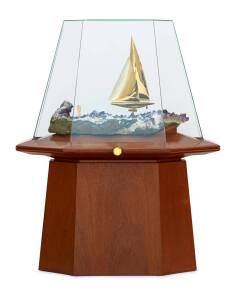 A spectacular gold model of the yacht "Australia II" in a display case