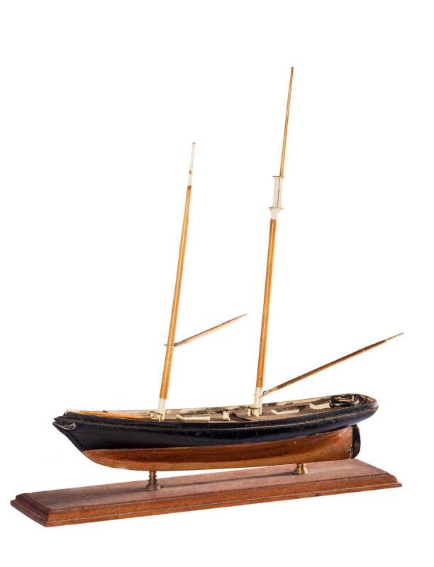 THE FIRST AMERICA'S CUP YACHT "AMERICA", timber scale model, partially rigged with masts and booms, mounted on turned brass supports on a timber base, 33cm long, 37cm tall.