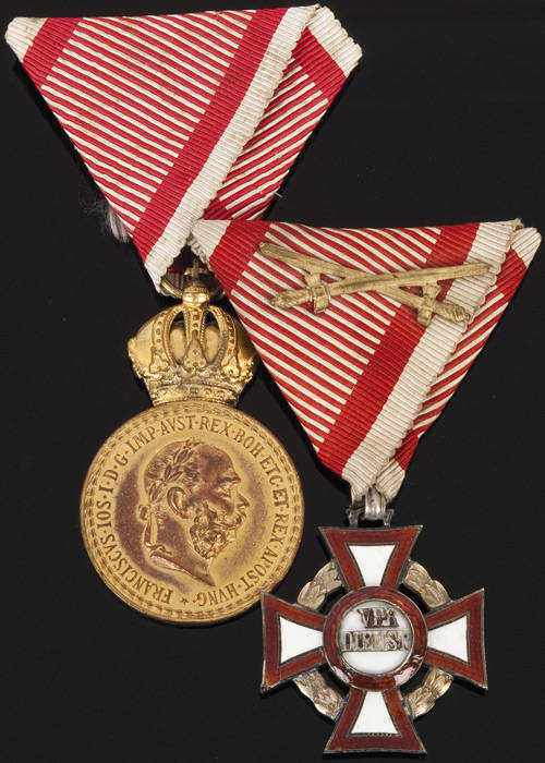 Military Medal of Merit with red & white ribbon; Military Cross of Merit (for distinction in front of the enemy) with red & white ribbon and swords. Both in original boxes, minor chipping to enamel. VG condition.