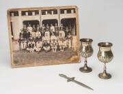 CRICKET & SWIMMING: Group with nice cricketer letter opener; c1920s team photograph of Burgher Recreation Club in Colombo, Sri Lanka; pair of silver-plated goblets, one engraved "Clifton College, Junior School, J.F.Hay, Swimming - 2 Lengths, July 1902". (