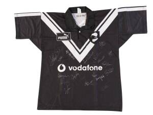 NEW ZEALAND "KIWIS" JERSEY, black with white "V" and "(kiwi)/  (fern)" badge on left breast, endorsed inside "29.10.99" (NZ defeated Great Britain 26-4), with 19 signatures on front including Richie Barnett, Nigel Vagana & Henry Paul.