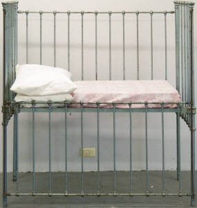 Childrens ward metal cot with operable sides.