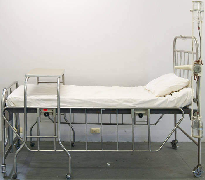 Adjustable hospital bed with associated table and equipment.