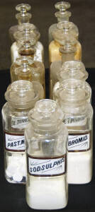 11 glass pharmacy bottles.