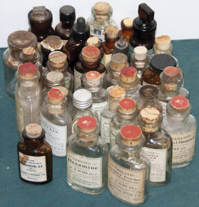 Range of small glass bottles, most with stoppers. Used to contain for example "Hexamine", "Gregory Powder", "Didymin", "Methyl-thiouracil", "Calomel", etc.