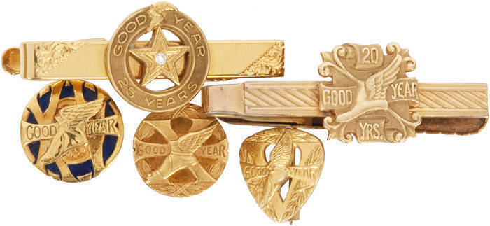 GOODYEAR SERVICE BADGES/TIE PINS: 5 Years service badge, 9ct gold (1.62g); 10 Years service badge, 9ct gold (3.07g); 15 Years service badge, 15ct gold & enamel (5.90g); 20 Years service, 15ct badge attached to 9ct rolled gold tie-pin; 25 Years service, 18