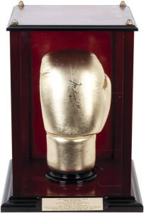 MUHAMMAD ALI, signature "Muhammad Ali 2000" on golden boxing glove, in attractive display case 32x32x43cm. Signed immediately prior to the Sydney 2000 Olympics, with Letter of Authenticity from the E.J.Whitten Foundation.