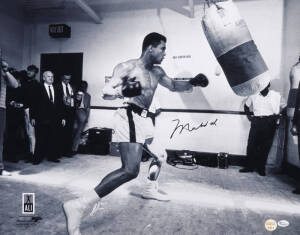 MUHAMMAD ALI, signed photograph of Muhammad Ali with punching bag, size 51x40cm. With 'Online Authentics' No.OA-8090272.