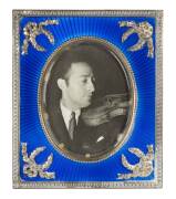 A Fabergé Russian silver and enamel photography frame, maker's mark of Michael Perchin [Perkhin], St Petersburg, before 1899, work master to Fabergé; the rectangular strut frame with beaded border and oval photograph of Heifetz, within blue sunray guilloc