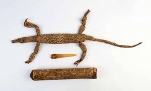 An Assortment of artefacts from Irian Jaya comprising a rattan woven crocodile, a ritual bone dagger and a carved bamboo flute; the rattan crocodile 81 cm long. Asmat tribal village, early 1990s.