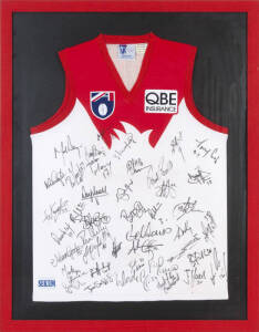 SYDNEY SWANS: Sydney Swans jumper signed by 1998 team, with c43 signatures including Paul Roos, Mark Bayes & Adam Goodes, window mounted, framed & glazed, overall 76x98cm.