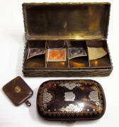 STAMP BOXES: c.1900-15 small plain brass 'envelope' fob with a 'pearl' inset; c.1925 American ceramic stamp roll dispenser; USA tortoise-shell case with a mother of pearl cross on one side and a thistle on the reverse. Stated to be unique, faults; Brass m