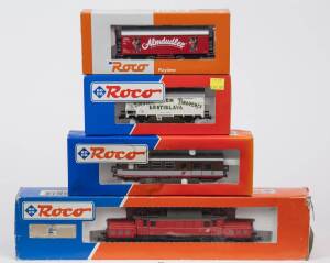 MODEL RAILWAYS: ROCO: OBB BR 1020 Electric Locomotive (43485), with Rolling Stock Comprising of OBB 2nd Class Passenger Car (34008), CSD Bratislava Pivovar Stein Brauerei Beer Car (48034), OBB &lsquo;Almdudler&rsquo; Refrigerated Freight Car (44585). All mint in orig