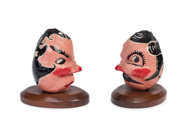 A pair of hand painted whale eardrums mounted on jarrah plinths, late 19th century