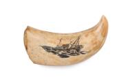 A scrimshaw whale's tooth with boating scene and inscription (illegible)