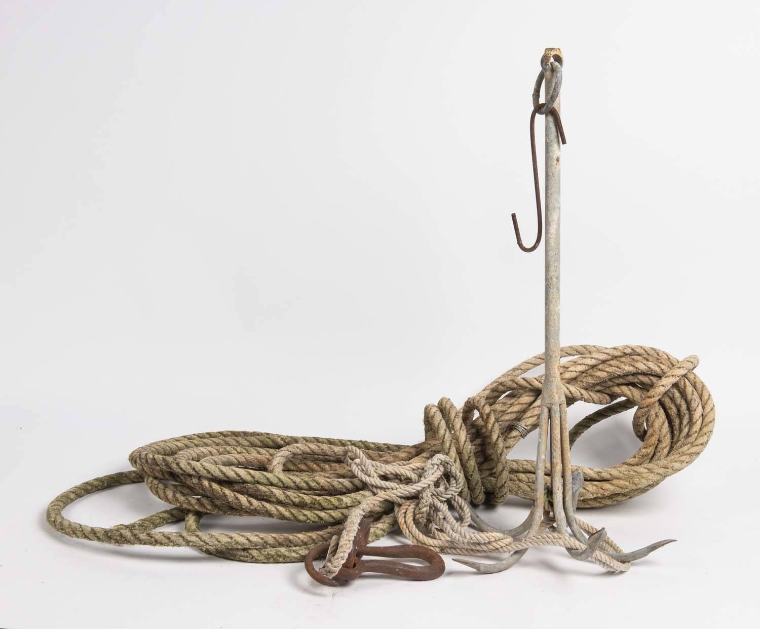 A boat anchor with old hemp rope and iron hook