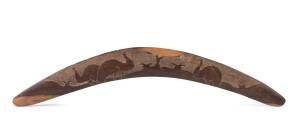 A boomerang with hand pecked emu motif, South Australian origin: together with a pith helmet