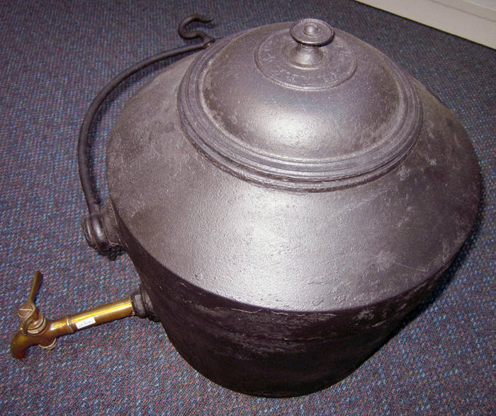 WATER URN. Antique English cast iron urn by "Clarke & Co.". Generous proportions (8 Gallons) with original brass tap and swing handle with hook. Has been reblacked. G condition.