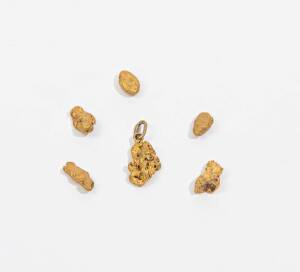 Six natural gold nuggets, one with a pendant ring, 9.7 grams total weight