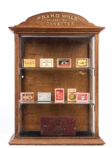 Oak cigarette dispenser, small cabinet with glass shelves, top with sign "W.D.& H.O.WILLS', Celebrated Cigarettes", size 37x51x20cm.