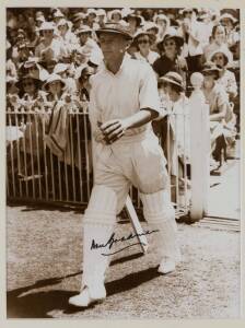 DON BRADMAN, lovely signature on sepia photograph of Bradman walking out to bat c1938, window mounted, framed & glazed, overall 43x51cm.