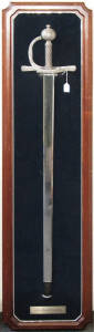 Sir Francis Drake replica sword, framed and mounted on navy blue cloth with plaque. Minor surface scratching to the wooden frame, 135 x 35cm, sword in excellent condition.