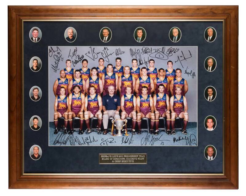 BRISBANE LIONS: 2001 Premiership Team photograph, central photograph signed by 21 players, surrounded by vignette photographs of Board of Directors, Coaching Staff & Chief Executive, window mounted, framed & glazed, overall 94x75cm. With Brisbane Lions Co