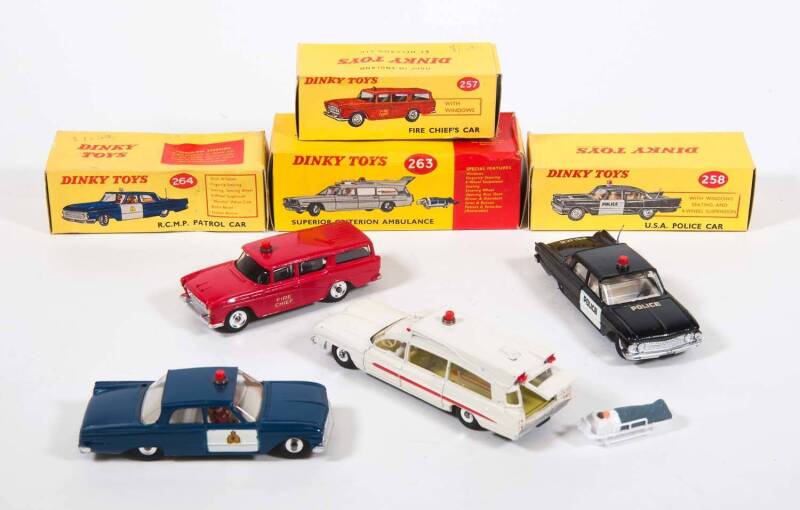 DINKY: 1960s Group of Emergency Vehicles Including Fire Chief’s Car (257); And, Superior Criterion Ambulance with Removable Patient and Stretcher (263); And, Ford Fairlane RCMP Police Car (264). Most mint in original yellow cardboard boxes (4 items)