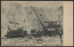 Queensland: Mount Morgan: 'Steam Shovel at Work Mt Morgan' postcard showing small Steam Locomotive on Railway Track hitched to Goods Wagons being loaded by Steam Shovel with bucket & derrick inscribed 'Mt. Morgan Gold Mining Co' and workers looking on, se