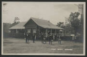 Queensland: Nanango: ‘Post Office Nanango’ real photo postcard (‘Empire’ back) with group of men - some carrying parcels - standing in front of the wooden building with large verandah and corrugated iron roof, unused, fine condition.