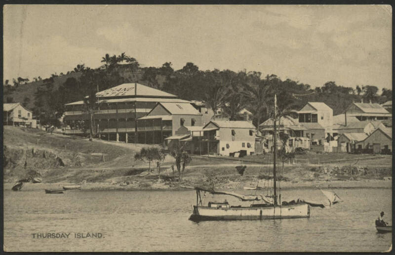 Queensland: Thursday Island: ‘Thursday Island’ postcard with Grand Hotel, township and Pearling Lugger boat in Harbour in foreground, unused, couple of blemishes.