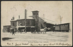 Sth Aust: Port Adelaide: ‘Railway Station, Port Adelaide’ postcard (published by J. Taylor Collotypist, Adelaide) showing Steam Locomotive and Train outside station with horse-drawn carriages awaiting passengers, sent to England with QV 1d red tied Adelai