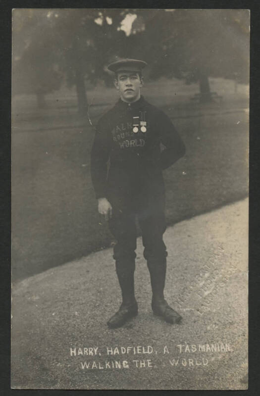 Tasmania: ‘Harry Hadfield, A Tasmanian Walking The World’ real photo card showing Harry wearing two medals and a jumper embroidered “Walking Around The World”, couple of minor blemishes. [According to the Hobart Mercury of 28.05.1907 Hadfield was twenty-t