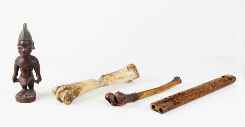 An African carved wood figure, 22cm high; a carved wood flute 32cm long and two bone implements 25 and 27cm long. (4 items).