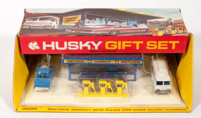 HUSKY (CORGI JUNIOR): Late 1960s Service Station Gift Set (3006) - Set Comprising of Garage Forecourt with Petrol Tanker, Ford Wreck Truck and Aston Martin. Mint in original red and yellow cardboard windowed display box with a mint inner carded base bubbl