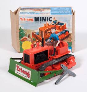TRIANG: Rare ‘Minic’ Series II Clockwork Powered Tractor with Bulldozer – Orange Plastic, Green Tinplate Bulldozer Marked with a Tri-Ang Sticker, Rubber Tracks & Plastic Driver Figure. Mint in original cardboard box with original clockwork key. 