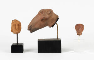 A Graeco-Roman terracotta head of a ram 13cm long together with two other small terracotta heads 5 and 7cm high. (3 items)