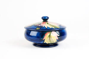 MOORCROFT: Berries & Leaves patterned lidded bowl on blue ground, c1930/40s. Width 14cm, height 10cm.